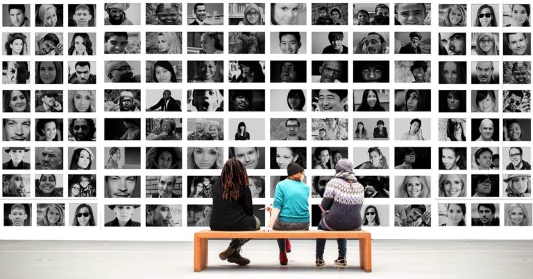 três pessoas sentadas diante de uma tela com dezenas de rostos - foto: Pixabay